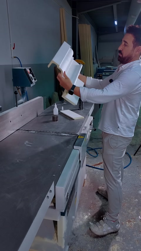 Een L-vormig kroonlijststuk vasthouden met lijm klaar op de werkbank