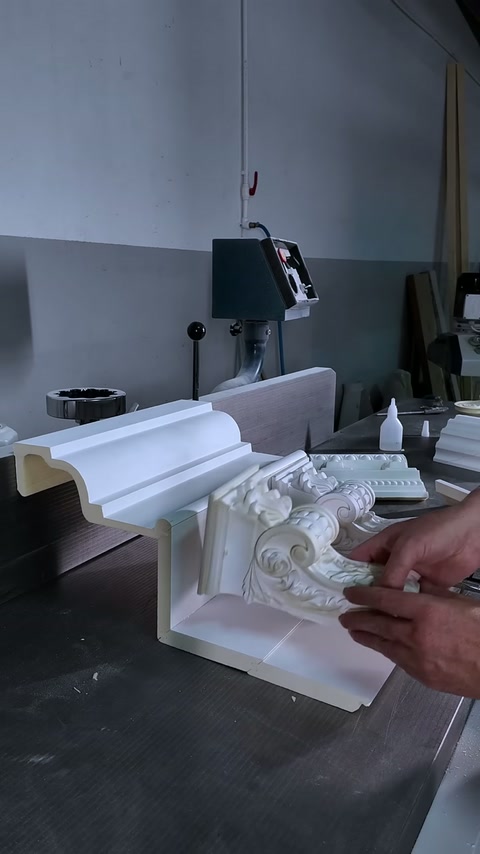 Sierlijk hoekornament is onder gelaagde lijst op de werkbank gepositioneerd.
