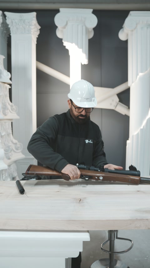 Dimostratur jiprepara rifle ta' arja fiċċa kampjuni dekorattivi tal-workshop.