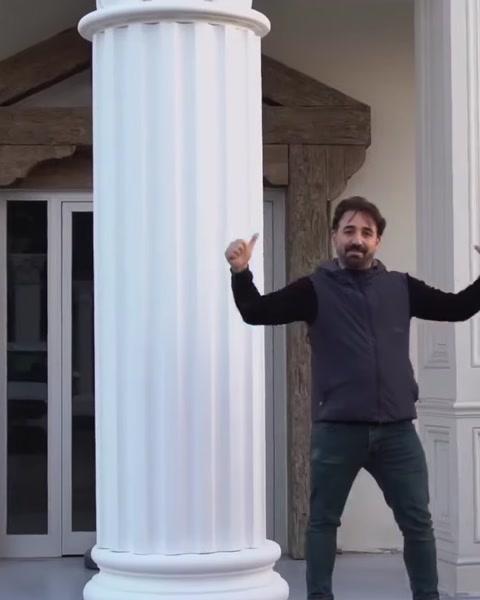 Mann posiert neben fertiger Polyurethan-Säule an Gebäude.