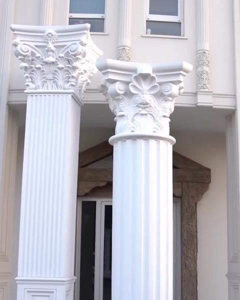 Zwei fertige gerillte Säulen stehen entlang Fassade.