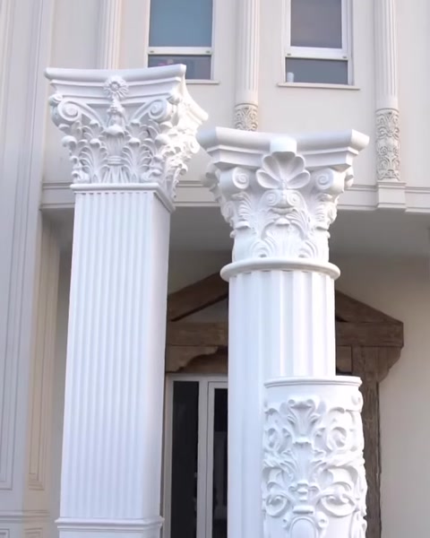 Zwei fertige gerillte Säulen mit korinthischen Kapitellen an Fassade.