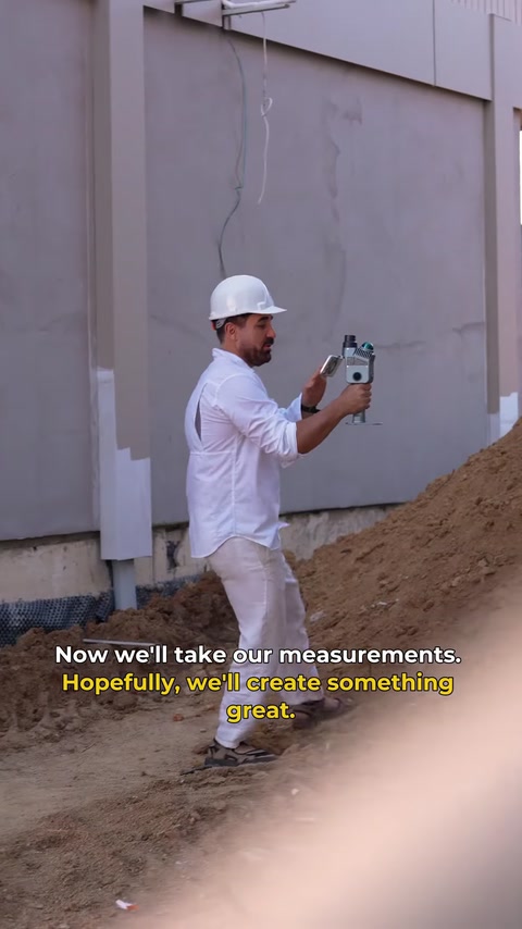 Un technicien scanne un mur inachevé pendant le relevé du site