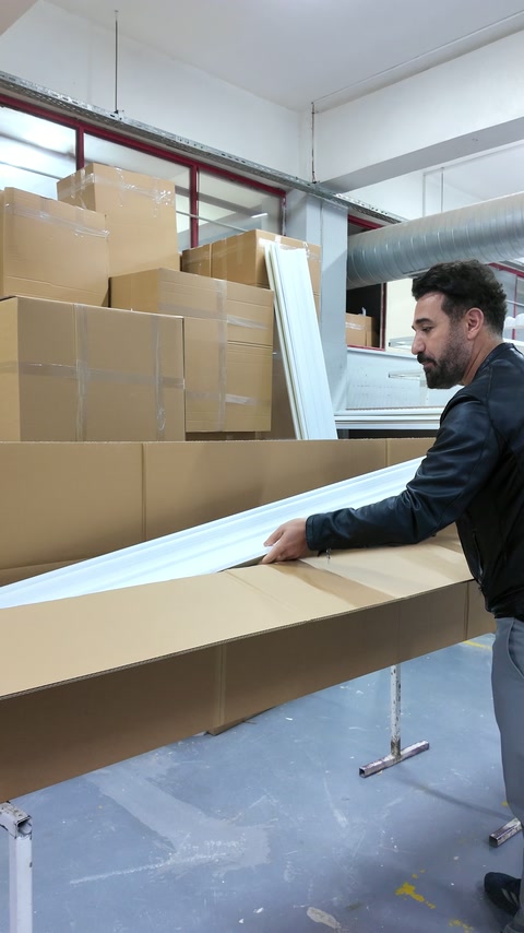 Moldura decorativa branca comprida colocada dentro da sua caixa de expedição