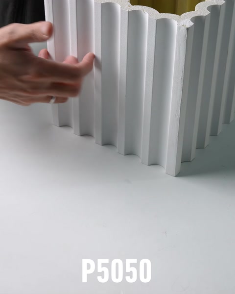 Perfil de columna estriada de poliuretano vacío de pie sobre mesa de taller