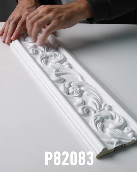 Manos deslizándose a lo largo de un panel decorativo de friso de poliuretano