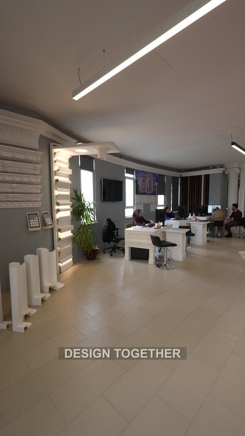 Weitläufiger Showroom-Innenraum mit Präsentationswänden, Arbeitsplätzen und Produktmustern