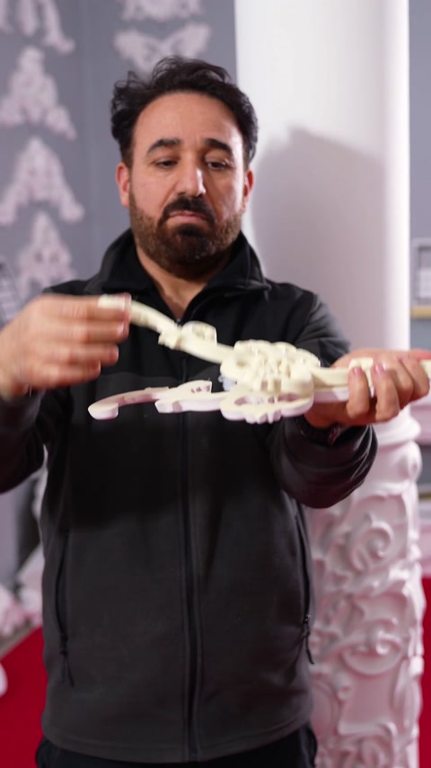 Prožni akantov ornament, upognjen v lok med dvema rokama