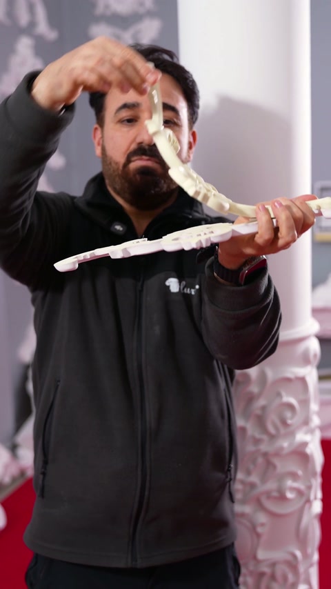 Obrtnik kaže prilagodljivost z upogibanjem enega konca ornamentike navzgor.