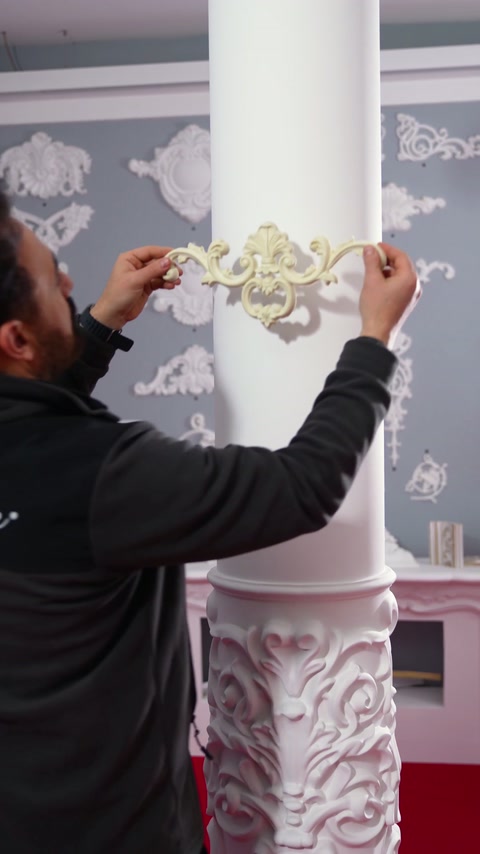 Instalater preveri postavitev ornamentike čez zaobljeno površino stebra.