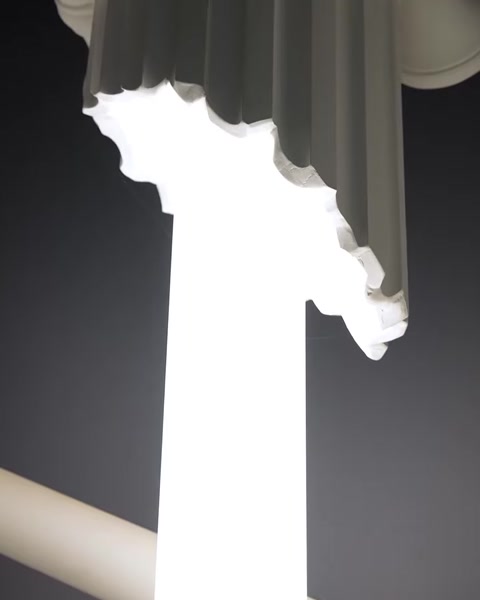 Detail shot of column crown with warm LED light emerging from crevice