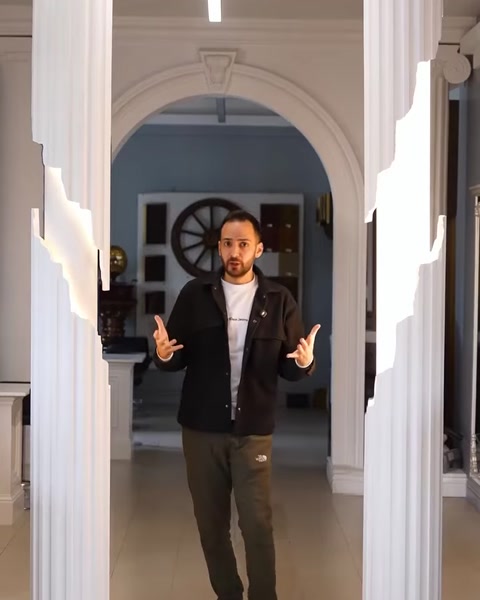 Man explaining column lighting options in showroom hallway