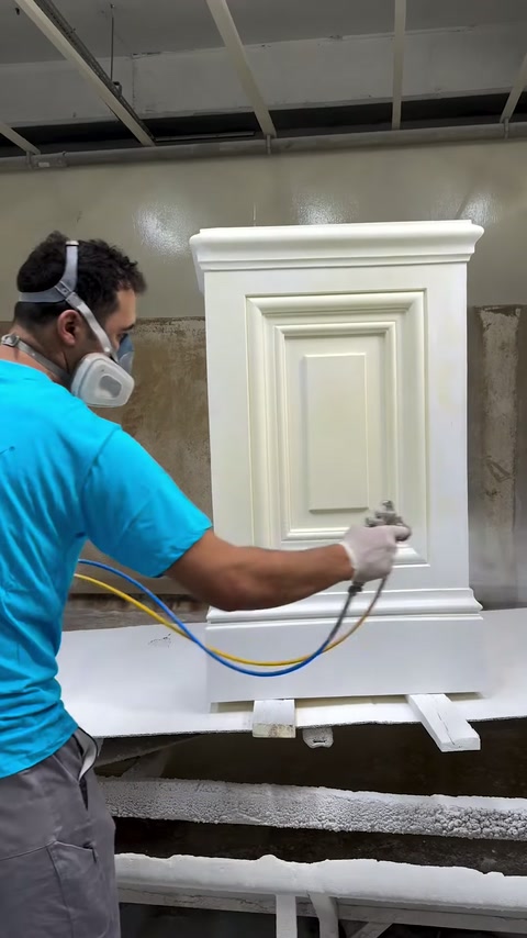 Un technicien applique une couche uniforme sur la surface d’un piédestal décoratif.