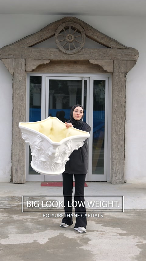 Une femme transporte un chapiteau corinthien surdimensionné à l’extérieur sans grand effort.