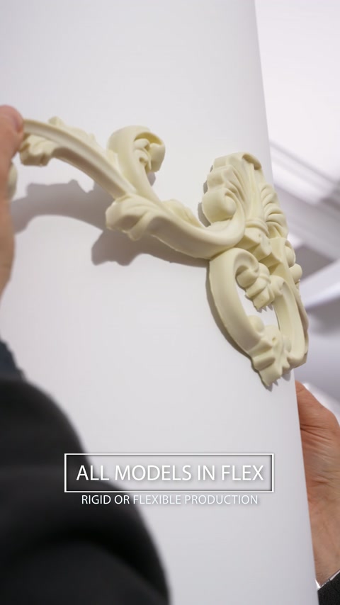 Des mains enroulent une applique flexible ornée autour d’une colonne circulaire.