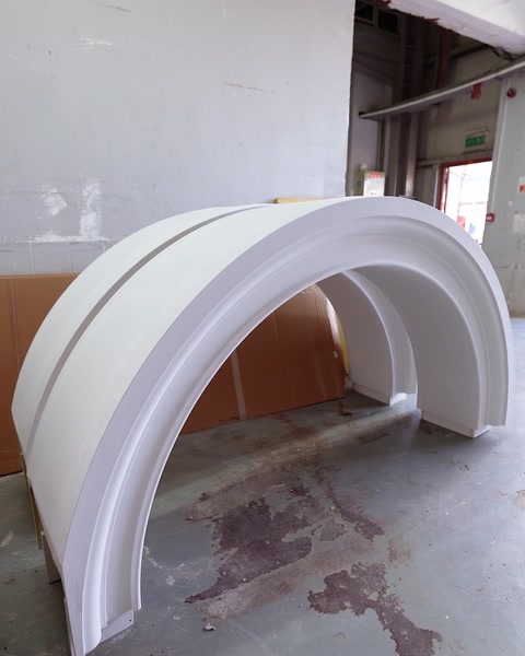 Wide-span polyurethane arch form resting against the workshop wall