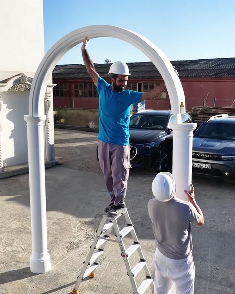 Worker on a ladder joining the arch to the column head