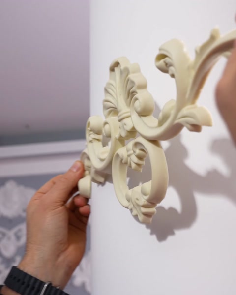 Detailní záběr odhaluje zdobný květinový ornament na stěně
