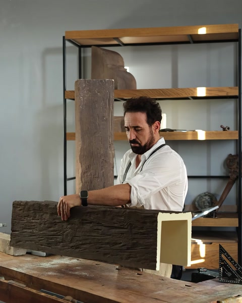 Řemeslník tvaruje architektonický trám s vzhledem dřeva v dílně