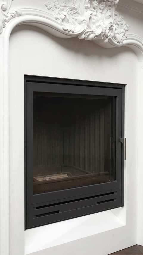 Ingebouwde zwarte inzet contrasteert met het gladde witte binnenframe van de schouwomkadering