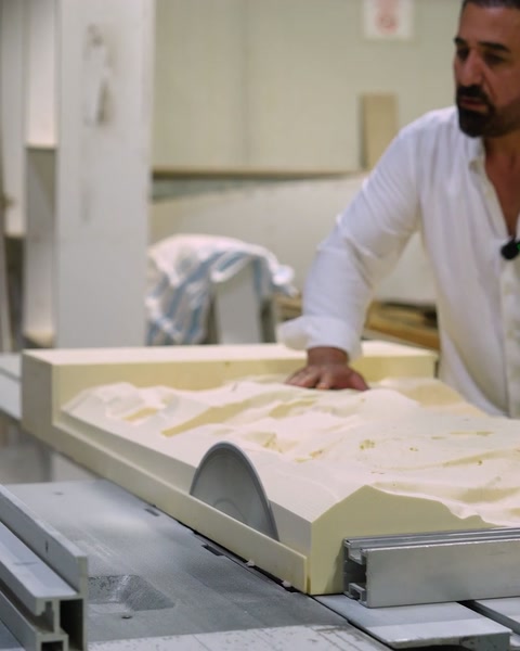 Pracovník prohlíží dokončený reliéfní panel v produkční oblasti