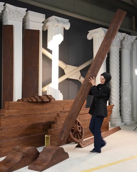 Žena zvedá diagonální polyuretanový trám, který demonstruje jeho lehký design