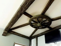 Rustic Ceiling Design with Polyurethane Beams and Wagon Wheel Centerpiece