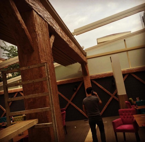 Decorazione rustica per locali con dettagli in legno e ferro <h2>Eleganza rustica e solidità del design</h2><p>Il concetto di arredamento rustico per ambienti commerciali sfrutta strutture imponenti con travi e colonne che imitano il legno naturale. L’uso del <strong>poliuretano</strong> consente di ottenere superfici solide e resistenti che ricordano la materia grezza senza richiedere la stessa manutenzione. L’effetto delle venature scolpite dona un senso di autenticità, creando un’atmosfera calda che accoglie clienti e ospiti con naturalezza.</p><h2>Dettagli decorativi e giochi geometrici</h2><p>Sulle pareti si notano intrecci a motivi a croce con elementi in <strong>ferro</strong> e inserti lignei che conferiscono ritmo alla superficie. Questa combinazione geometrica non solo rafforza la stabilità visiva della sala ma introduce un tocco di artigianato che riecheggia le antiche costruzioni rurali, dove legno e ferro erano materiali fondamentali. Le sedute in tessuto dai colori vivaci bilanciano la rusticità dei materiali strutturali, offrendo comfort e vivacità.</p><h2>Armonia tra tradizione e modernità</h2><p>Un locale con queste caratteristiche non è soltanto funzionale, ma evoca anche la tradizione architettonica. In passato, l’uso delle travi lignee scolpite era tipico dei rifugi e delle case contadine, mentre oggi, grazie alle soluzioni innovative come il <strong>rivestimento in poliuretano</strong>, è possibile riprodurre questi elementi senza sacrificare praticità e durata. Il risultato è uno spazio che invita alla convivialità, perfetto per ristoranti, caffè o sale eventi.</p><ul><li>Strutture imponenti con colonne scolpite</li><li>Motivi geometrici a croce in ferro e legno</li><li>Sedute dai colori brillanti che creano contrasto</li><li>Uso del <strong>design rustico</strong> con elementi moderni</li></ul>

<p>Un ambiente arredato con travi e colonne in <strong>poliuretano</strong> riproduce la bellezza del legno rustico. Le superfici scolpite e ricche di venature trasmettono calore. L’uso di <strong>ferro</strong> negli intrecci decorativi aggiunge solidità. Le pareti presentano disegni geometrici incrociati con forte impatto visivo. Le sedute colorate creano un equilibrio moderno. Questo spazio diventa funzionale e accogliente. La combinazione cromatica vivace riscalda l’atmosfera. I dettagli lavorati donano carattere autentico. La <strong>decorazione rustica</strong> evoca tradizione e artigianato. La resistenza dei materiali rende l’ambiente durevole. Gli elementi strutturali esaltano l’armonia dello spazio. Il contrasto tra moderno e classico è ben bilanciato. L’arredo stimola comfort e convivialità. La scelta del <strong>design rustico</strong> rafforza l’identità del locale. Questa soluzione soddisfa esigenze estetiche e pratiche.</p>