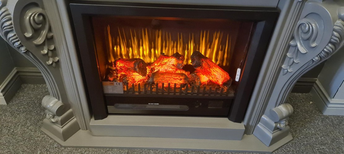 Klasyczny kominek dekoracyjny z poliuretanu do eleganckich wnętrz <h2>Elegancja klasycznego kominka poliuretanowego</h2><p>Kominek dekoracyjny wykonany z <strong>poliuretanu</strong> prezentuje wyjątkowy styl, który znakomicie wpisuje się w aranżacje willi, salonów i przestrzeni o charakterze klasycznym. Jego masywna rama zdobiona jest rzeźbionymi <strong>ornamentami</strong>, w tym spiralnymi liniami oraz motywami roślinnymi, które nawiązują do dawnych tradycji sztuki zdobniczej.</p><p>Centralna część kominka oferuje realistyczne odwzorowanie <strong>płomieni</strong> i żarzących się polan, tworzących efekt przytulności i naturalnego ciepła. Efekt wizualny daje poczucie autentycznego ogniska, a jednocześnie pozostaje praktyczny i bezpieczny w użytkowaniu.</p><h2>Detale i wzornictwo</h2><p>Kolorystyka kominka utrzymana w eleganckiej szarości podkreśla klasyczne formy i dodaje wnętrzu subtelnej harmonii. Dekoracyjne elementy boczne w formie spiralnych wolut przypominają rozwiązania znane ze sztuki barokowej, a delikatne detale kwiatowe łagodzą monumentalność całości. Takie wzornictwo sprawia, że kominek stanowi nie tylko funkcjonalny element, lecz także unikalną <strong>ozdobę</strong>.</p><p>Historia użycia zdobień inspirowanych architekturą antyczną sprawia, że forma kominka nawiązuje do tradycji europejskich wnętrz, gdzie dbałość o detal była symbolem prestiżu i luksusu.</p><h2>Zastosowanie</h2><p>Tego rodzaju kominek pełni rolę doskonałego elementu <strong>dekoracyjnego</strong>. Sprawdzi się zarówno jako centralny punkt reprezentacyjnego salonu, jak i stylowego gabinetu. Dzięki swojej formie łączy klasyczną estetykę z nowoczesnymi efektami wizualnymi.</p>

<p>Ten klasyczny kominek wykonany z <strong>poliuretanu</strong> łączy elegancję tradycyjnych wnętrz z nowoczesnym komfortem. Bogate <strong>ornamenty</strong> w formie spiralnych wolut i roślinnych motywów nadają całości wyjątkowej głębi. Efekt realistycznych <strong>płomieni</strong> tworzy atmosferę ciepła i spokoju. Styl ten z łatwością komponuje się z wnętrzami willowymi lub luksusowymi salonami. Subtelna szarość ramy uwydatnia detale i wprowadza harmonię. Dekoracyjny charakter sprawia, że kominek staje się głównym punktem aranżacji. Inspiracja architekturą antyczną nadaje mu ponadczasowy wymiar. Wzory spiralne nawiązują do historycznych motywów dekoracyjnych. Formy roślinne łagodzą monumentalność konstrukcji. Połączenie tradycji i nowoczesności dodaje mu niepowtarzalności. Drobiazgowe zdobienia symbolizują luksus i prestiż. Realistyczne polana wzmacniają iluzję naturalnego ognia. Praktyczny wymiar idzie w parze z wysoką estetyką. To idealny wybór dla osób szukających stylowej <strong>ozdoby</strong>. Klasyczna forma zapewnia, że kominek nigdy nie wyjdzie z mody.</p>