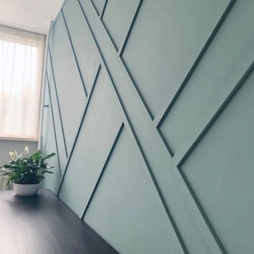 Poliuretanowa dekoracyjna listwa ścienna w nowoczesno-klasycznej willi <h2>Poliuretanowa listwa ścienna – estetyka nowoczesno-klasyczna</h2><p>Ściana ozdobiona <strong>poliuretanową listwą</strong> dekoracyjną stanowi doskonałe połączenie prostoty formy z dekoracyjnym akcentem. Ukośne i krzyżujące się linie budują efektowną <strong>geometrię</strong>, która nadaje przestrzeni wyrazistości oraz unikalnego charakteru. Nadaje to wnętrzu rytm i plastyczność, a jednocześnie pozostaje spójne ze stylem modern-classic.</p><p>Kolor w odcieniu jasnego błękitu działa uspokajająco oraz optycznie powiększa pomieszczenie. Przełamany dzięki listewkom kontrast cienia i światła czyni ścianę bardziej trójwymiarową. Motywy geometryczne tego rodzaju mają swoje źródła w klasycznych dekoracjach ściennych, które wykorzystywano już w renesansowych oraz barokowych wnętrzach, chociaż tutaj przekształcono je w minimalistyczną, <strong>nowoczesną formę</strong>.</p><p>Wnętrze uzupełnia delikatny akcent roślinny, który wprowadza balans pomiędzy twardością geometrycznych układów a miękkością natury. Całość tworzy bazę, którą można rozwinąć za pomocą eleganckich mebli i oświetlenia.</p><ul><li><strong>Listwa dekoracyjna</strong> podkreśla rytm i dynamikę ściany.</li><li>Kolor błękitny podnosi świeżość aranżacji.</li><li><strong>Geometryczne linie</strong> nadają wnętrzu nowoczesnego sznytu.</li><li>Drobne klasyczne odniesienia w minimalistycznym ujęciu.</li></ul>

<p>Nowoczesno-klasyczne wnętrza zyskują unikalny charakter dzięki ścianom zdobionym przez poliuretanowe listwy. Geometria ukośnych linii tworzy rytm i wizualną głębię. Jasnoniebieski kolor nadaje elegancji i powiększa przestrzeń. Efekt światła i cienia dodatkowo wzmacnia dekoracyjny układ. Tego rodzaju <strong>listwa dekoracyjna</strong> sprawdza się w salonach i gabinetach. Styl modern-classic łączy prostotę i elegancję. Historyczne inspiracje wzbogacają nowoczesne aranżacje. <strong>Geometryczne linie</strong> zapewniają porządek i harmonię. Minimalizm splata się z subtelną ozdobnością. Kontrast z roślinnymi akcentami przynosi równowagę. Ściana nabiera wyrazistości i charakteru. <strong>Poliuretan</strong> gwarantuje trwałość oraz łatwość montażu. Rozwiązanie wspiera aranżacje klasyczne i współczesne. Projekt jest funkcjonalny i estetyczny. To idealny wybór do eleganckiej willi.</p>