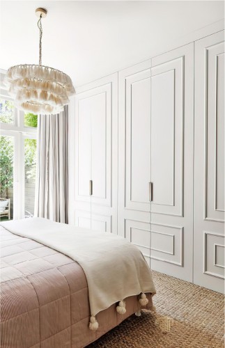 Modern-klassische Eleganz mit Polyurethanleisten im Schlafzimmer und TV-Wand <h2>Stilvolle Schlafzimmergestaltung mit Polyurethanleisten</h2><p>Die Verwendung von <strong>Polyurethanleisten</strong> an den Schrankfronten sorgt für eine raffinierte Tiefe, die an klassische Wandvertäfelungen erinnert. Diese rechteckigen Reliefmuster sind streng geometrisch aufgebaut, wodurch ein harmonischer Rhythmus an der langen Schrankwand entsteht. Solche Formen finden ihre Wurzeln in der Architektur der Neuzeit, in der Klarheit und Dekoration oft miteinander verbunden wurden.</p><p>Im Gegensatz zu den klaren Strukturen des <strong>Wanddesigns</strong> bringt der Kronleuchter mit seinen weichen, textilen Rüschen einen verspielten Touch in den Raum. Die mehrlagige Komposition der Leuchte wirkt fast skulptural und schafft ein Gegengewicht zur geradlinigen Formensprache.</p><h2>Materialität und Textur</h2><p>Das Bett zeigt mit seiner feinen, vertikalen Steppung ein betont ruhiges Muster, das von einer leichten Decke mit Quasten ergänzt wird. Dieser handwerklich wirkende Abschluss verleiht dem Raum eine persönliche Note. Der Boden in geflochtener Naturfaser bringt eine <strong>organische Textur</strong> ein und harmoniert mit den hellen Flächen.</p><p>Insgesamt entsteht eine Atmosphäre, in der <strong>modernes Design</strong> und klassische Eleganz verschmelzen. Die Kombination aus klaren Linien, leichten Ornamenten und textilen Kontrasten lässt den Raum wohnlich und zugleich repräsentativ wirken.</p><ul><li>Polyurethanleisten für dezente Ornamentik</li><li>Geometrische Rahmungen an den Schranktüren</li><li>Textile Leuchte als dekorativer Akzent</li><li>Geflochtene Naturfaser für warme Haptik</li></ul>

<p>Dieses Schlafzimmer zeigt eine zurückhaltende Verschmelzung von Moderne und Klassik. Die Polyurethanleisten verleihen den Schrankfronten reliefartige Tiefe. Geometrische Formen schaffen einen geordneten Rhythmus und klare Linien. Der Kronleuchter setzt mit textilen Schichten einen spielerischen Kontrast. Seine mehrlagige Struktur wirkt fast skulptural. Die Hängelampe hebt sich durch ihre weiche Formensprache ab. Das Bett ist durch subtile Steppungen geprägt. Eine Decke mit Quasten sorgt für handwerklichen Charme. Der Boden aus geflochtener Naturfaser bringt eine <strong>warme Textur</strong> in den Raum. Schlichtes Weiß unterstreicht die visuelle Weite. Helle Vorhänge ergänzen die Lichtfülle der Fensterfront. Die Gestaltung erinnert an klassische Raumproportionen. Gleichzeitig vermittelt sie eine <strong>moderne Ruhe</strong>. Ornamentik bleibt minimalistisch und elegant. So entsteht eine <strong>zeitlose Ästhetik</strong>.</p>