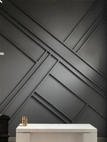 Decorazione minimalista in poliuretano per salotto moderno classico <h2>Geometria e design elegante</h2><p>La parete in <strong>poliuretano</strong> con disegni incrociati evidenzia la tendenza verso una decorazione <strong>minimalista</strong>. L'uso di linee parallele e diagonali sovrapposte crea un motivo tridimensionale di grande impatto visivo e aggiunge un senso di dinamismo all'ambiente.</p><p>La finitura grigio scuro valorizza i contrasti di luce e ombra, mentre la superficie liscia offre un aspetto pulito e coerente con gli <strong>interni moderni</strong>. La combinazione tra struttura rigida e leggerezza del materiale rende questa soluzione ideale per spazi eleganti e armoniosi.</p><h2>Armonia tra classico e moderno</h2><p>Inserire questo tipo di rivestimento in un salotto significa unire il fascino del <strong>design classico</strong> con la freschezza dello stile contemporaneo. Le proporzioni geometriche richiamano alcuni principi architettonici storici, come l’uso di simmetrie e ritmo visivo già presenti nell’architettura neoclassica.</p><p>Il decoro non necessita di elementi aggiuntivi per distinguersi: le forme semplici ma precise reggono da sole la composizione. Accanto a mobili chiari o a dettagli raffinati in metallo, la parete diventa una scenografia che integra e valorizza l’intero ambiente.</p><h2>Versatilità estetica</h2><p>Grazie alla sua natura modulare, il <strong>poliuretano decorativo</strong> consente soluzioni personalizzate. È resistente, leggero e facilmente adattabile alle diverse esigenze progettuali. Con questa tecnica si ottiene un forte senso di ordine e di identità stilistica che eleva ogni salotto in chiave moderna classica.</p>

<p>Il salotto moderno classico con rivestimento in <strong>poliuretano</strong> trova una sintesi elegante tra tradizione e innovazione. Le linee oblique incrociate generano un effetto tridimensionale dinamico. La superficie scura valorizza i contrasti naturali di luce. L’insieme appare pulito e rigoroso. Lo stile <strong>minimalista</strong> non sacrifica la ricchezza visiva. I rilievi regolari favoriscono la percezione di profondità. La geometria diventa un linguaggio decorativo sobrio ma d’impatto. Ogni dettaglio contribuisce a creare armonia visiva. La combinazione con mobili chiari rafforza l’eleganza dello spazio. La leggerezza del <strong>materiale</strong> rende l’applicazione funzionale. L’ispirazione classica si fonde con tratti moderni. La scelta cromatica rafforza il senso di continuità. Gli incastri geometrici si trasformano in elemento caratterizzante. L’effetto complessivo è sofisticato e stabile. La decorazione così concepita diventa un riferimento per interni <strong>contemporanei</strong>.</p>