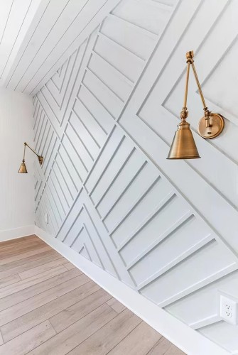 Parete moderna con motivi geometrici in poliuretano e dettagli in ottone <h2>Geometria e design moderno</h2><p>Le modanature in <strong>poliuretano</strong> permettono di creare effetti tridimensionali raffinati, come mostrato da questa parete unica in cui le linee diagonali e parallele formano un motivo geometrico dinamico. L'uso sapiente delle angolature dona un senso di movimento e allo stesso tempo ordine visivo, trasformando una semplice superficie in un elemento protagonista dell'ambiente.</p><h2>Materiali e dettagli</h2><p>L'unione tra la leggerezza del <strong>poliuretano</strong> e la resistenza del <strong>legno</strong> chiaro del pavimento crea un contrasto elegante e armonioso. Gli inserti in ottone delle applique contribuiscono ad aggiungere un tocco classico e senza tempo, equilibrando l'aspetto moderno dei rilievi geometrici.</p><h2>Atmosfera e stile</h2><p>Le superfici bianche con motivi a rilievo facilitano la diffusione della luce e rendono l'ambiente luminoso e arioso. L'effetto complessivo è quello di un salone che unisce <strong>minimalismo</strong> e raffinatezza, garantendo comfort visivo e originalità stilistica. La disposizione delle forme richiama l'arte astratta e contemporanea, rendendo lo spazio unico.</p><h2>Cenni storici</h2><p>L'uso delle modanature ha origini antiche, già diffuse nell'architettura classica greca e romana. In epoca moderna, grazie a materiali innovativi come il <strong>poliuretano</strong>, queste tecniche si sono evolute, permettendo di reinterpretare elementi classici in chiave contemporanea.</p>

<p>La parete con rilievi in <strong>poliuretano</strong> rappresenta un esempio di design che unisce estetica e funzionalità. Le linee geometriche creano un ritmo visivo che arricchisce lo spazio. L'inserimento delle applique in <strong>ottone</strong> offre calore e un contrasto sofisticato. Il pavimento in <strong>legno</strong> chiaro bilancia la freddezza delle superfici bianche. Le geometrie diagonali comunicano movimento e modernità. Ogni dettaglio dona una sensazione di armonia complessiva. La scelta del poliuretano garantisce leggerezza e durabilità. Questa soluzione decorativa è ideale per soggiorni eleganti. L'effetto tridimensionale rende le superfici più interessanti. La luce naturale esalta i rilievi e ne amplifica l'impatto. L'atmosfera cosmopolita si combina con elementi accoglienti. Il risultato è uno spazio che trasmette calma ed energia allo stesso tempo. Le radici classiche delle modanature dialogano con la ricerca moderna. Questo progetto dimostra come semplicità e dettaglio possano coesistere. Lo stile finale riflette un equilibrio tra innovazione e tradizione.</p>