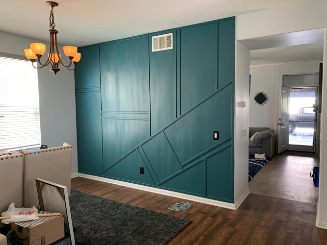 Poliurethan Wandpaneele mit geometrischen Profilen für modernen-klassischen Wohnstil <h2>Moderner-klassischer Wohnstil mit Poliurethan-Wandprofilen</h2><p>Die Gestaltung des Wohnzimmers schöpft ihre Wirkung aus einer markanten Wand, die mit <strong>Poliurethan-Leisten</strong> in geometrischen Mustern veredelt wurde. Diagonale Linien kreuzen sich mit waagerechten Segmenten und schaffen ein spannendes Spiel aus Formen und Tiefen. Durch die dezente Schattenwirkung gewinnt die Wand eine fast plastische Dimension.</p><p>Die satt <strong>türkisgrüne</strong> Oberfläche unterstreicht die moderne Seite des Raumes, während die klassische Wirkung der Profile eine Verbindung zu historischen Interieurs herstellt. Bereits in der Renaissance und im Barock wurden Zierleisten eingesetzt, um Räume aufzuwerten – hier erscheinen sie in einer zeitgemäßen Neuinterpretation.</p><p>Der Kontrast zum warmen <strong>Holzboden</strong> schafft Behaglichkeit, und das helle Wand- und Deckenfinish sorgt für visuelle Balance. Ergänzt durch eine schlichte Leuchte mit klassischem Charme, wirkt die Kombination sowohl modern als auch traditionsbewusst.</p><ul><li>Geometrische <strong>Wandakzente</strong> als Blickfang</li><li>Lackierbare Oberflächen für individuelle Gestaltung</li><li>Kombination von klassischer Form und moderner Farbe</li></ul>

<p>Die Kombination von <strong>Poliurethan-Leisten</strong> und kräftigen Farbtönen zeigt, wie traditionelles Dekor zeitgemäß inszeniert werden kann. Die diagonalen und horizontalen Linien fügen der Wand visuelle Spannung hinzu. Die grünlich-türkise Farbe erzeugt einen modernen Akzent. Das warme <strong>Holzparkett</strong> schafft einen ausgleichenden Kontrast. Die klassische Struktur der Leisten bringt Raffinesse. Eine sanfte Lichtführung setzt die Wand zusätzlich in Szene. Das Zusammenspiel von materieller Klarheit und dekorativer Formgebung prägt den Stil. Die Gestaltung ist vielseitig anpassbar. Lackierbare Elemente ermöglichen individuelle Farbkombinationen. Klassische Interieurs gewinnen damit moderne Frische. Der Raum erscheint großzügig und gleichzeitig gemütlich. Die Akzentwand wird zum gestalterischen Mittelpunkt. <strong>Geometrische Profile</strong> betonen den Rhythmus des Designs. Diese Technik lässt sich auf unterschiedliche Raumgrößen übertragen. Insgesamt entsteht ein harmonisches Beispiel für modernen-klassischen Wohnstil.</p>