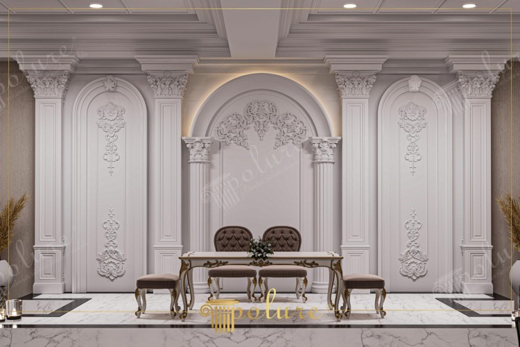 Modelos clássicos de decoração em poliuretano para casamentos elegantes <h2>Decoração clássica em poliuretano</h2><p>O design em <strong>poliuretano</strong> oferece não apenas durabilidade, mas também uma estética refinada que combina ornamentos barrocos e elementos arquitetônicos clássicos. Os painéis de parede apresentam <strong>motivos florais</strong>, arabescos e molduras geométricas em relevo, proporcionando profundidade visual e imponência. As colunas, coroadas com capitéis coríntios, remetem aos grandes templos da Antiguidade, reforçando a linguagem arquitetônica tradicional.</p><p>O conjunto inclui arcos cuidadosamente delineados com adornos curvos e simétricos, que trazem harmonia e equilíbrio à composição. O mobiliário de linhas sinuosas, enriquecido com dourados trabalhados em sua madeira esculpida, forma uma base perfeita para celebrações de casamentos clássicos. As cadeiras estofadas em veludo marrom contrastam com a suavidade das paredes claras, elevando a sofisticação do espaço.</p><p>O piso em <strong>mármore</strong> branco com veios cinzentos foi projetado para complementar a paleta cromática nobre do cenário, criando um equilíbrio entre frescor e elegância. Pequenos detalhes dourados e iluminação embutida em torno dos arcos ampliam a sensação de profundidade e ressaltam os relevos decorativos. Historicamente, o uso de colunas ornamentadas e arabescos em painéis remonta ao auge do barroco europeu, quando luxo e teatralidade se tornaram referências de poder e prestígio.</p><ul><li>Colunas clássicas com capitéis coríntios</li><li>Painéis com relevos florais e arabescos</li><li>Mobiliário com detalhes dourados</li><li>Piso em mármore refinado</li></ul>

<p>Este ambiente de <strong>decoração clássica</strong> combina perfeitamente o prestígio do poliuretano com formas arquitetônicas tradicionais. As colunas coríntias acrescentam uma presença imponente ao espaço. Os painéis detalhados com <strong>motivos florais</strong> criam uma atmosfera delicada. O mobiliário com detalhes dourados oferece elegância atemporal. As cadeiras em veludo marrom adicionam contraste sofisticado. O piso em <strong>mármore</strong> contribui para uma base de luxo. A iluminação embutida valoriza cada detalhe ornamental. Os arcos simétricos reforçam a ideia de equilíbrio e tradição. Cada elemento foi pensado para compor um cenário majestoso. A união entre design clássico e materiais modernos garante durabilidade. O estilo evoca o esplendor do barroco europeu. Este espaço é ideal para cerimônias de casamento refinadas. A distribuição geométrica mantém a harmonia do projeto. Os entalhes em relevo oferecem textura visual rica. O resultado final traduz sofisticação e imponência em cada detalhe.</p>