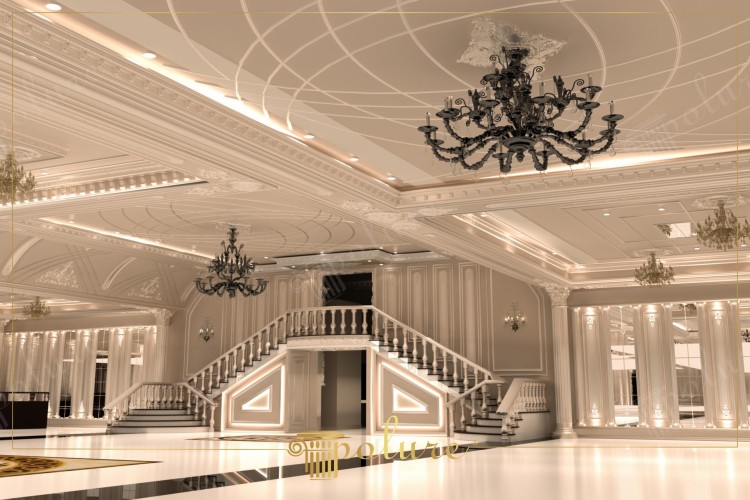 Decorazione classica in poliuretano per interni di una sala matrimoni elegante <h2>Dettagli architettonici classici</h2><p>La sala presenta una cura estremamente precisa dei <strong>dettagli</strong> architettonici. Le cornici e i fregi in <strong>poliuretano</strong> con motivi floreali e geometrici si fondono armoniosamente con pareti e colonne, creando una superficie ricca di texture.</p><p>Lo scalone scenografico con doppia scalinata è illuminato da luci integrate che sottolineano le forme triangolari nelle basi. Questo elemento, oltre alla funzione pratica, ha un importante significato estetico e valorizza lo spazio principale della sala.</p><h2>Design del soffitto</h2><p>Il soffitto combina rilievi classici con motivi geometrici, arricchiti da linee curve e circolari che incorniciano i lampadari centrali. Le lavorazioni ricordano le decorazioni dei palazzi ottocenteschi, ma realizzate con materiali più leggeri e durevoli.</p><ul><li>Linee concentriche che creano profondità visiva.</li><li>Motivi floreali attorno ai lampadari.</li><li>Cornici luminose che danno continuità allo spazio.</li></ul><h2>Illuminazione e atmosfera</h2><p>I grandi lampadari in ferro dal colore scuro creano un contrasto deciso con le tonalità chiare delle superfici. La luce calda, diffusa dalle cornici e dalle applique, dona un’atmosfera avvolgente e teatrale. Questo gioco di contrasti tra luce e ombra mette in risalto la <strong>decorazione classica</strong> in tutte le sue forme.</p><p>Un breve cenno storico: l’uso delle cornici e delle modanature decorative ha origine già nell’architettura greco-romana, dove colonne e fregi venivano impiegati per comunicare ordine e armonia. Qui la stessa logica è reinterpretata con mezzi moderni.</p><h2>Composizione estetica</h2><p>Il connubio di elementi moderni, come l’illuminazione LED, e dettagli neoclassici, come i profili scolpiti, rende la sala un modello unico di <strong>design</strong> classico contemporaneo. I motivi geometrici, le texture delle cornici, e le forme eleganti delle scale contribuiscono a creare uno spazio ideale per celebrare eventi formali e memorabili.</p>
<p>Questa sala matrimoni classica cattura lo sguardo con le sue decorazioni in <strong>poliuretano</strong> dettagliate. Le cornici e i fregi danno continuità alle pareti con eleganza raffinata. Il soffitto è arricchito da motivi geometrici che creano ritmo visivo. Gli elementi circolari incorniciano i punti luce in modo equilibrato. I lampadari scuri forniscono un contrasto ricco con gli interni chiari. Le balaustre bianche dello scalone trasmettono imponenza. L’uso dell’illuminazione LED risalta le linee architettoniche. La <strong>decorazione classica</strong> si unisce a soluzioni moderne per un equilibrio unico. Le colonne con rilievi floreali evocano un linguaggio neoclassico. Le superfici avorio e dorate creano un effetto scenografico. I motivi floreali intagliati richiamano la tradizione ottocentesca. Il design complessivo della sala combina lusso e funzionalità. Ogni elemento del contesto parla di eleganza e maestosità. La struttura interna è pensata per celebrare con grandiosità gli eventi. La cura dei <strong>dettagli</strong> rende questa sala un modello ideale di <strong>design</strong> classico contemporaneo.</p>